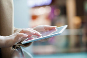 A person offscreen holds a tablet.