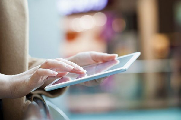 A person offscreen holds a tablet.